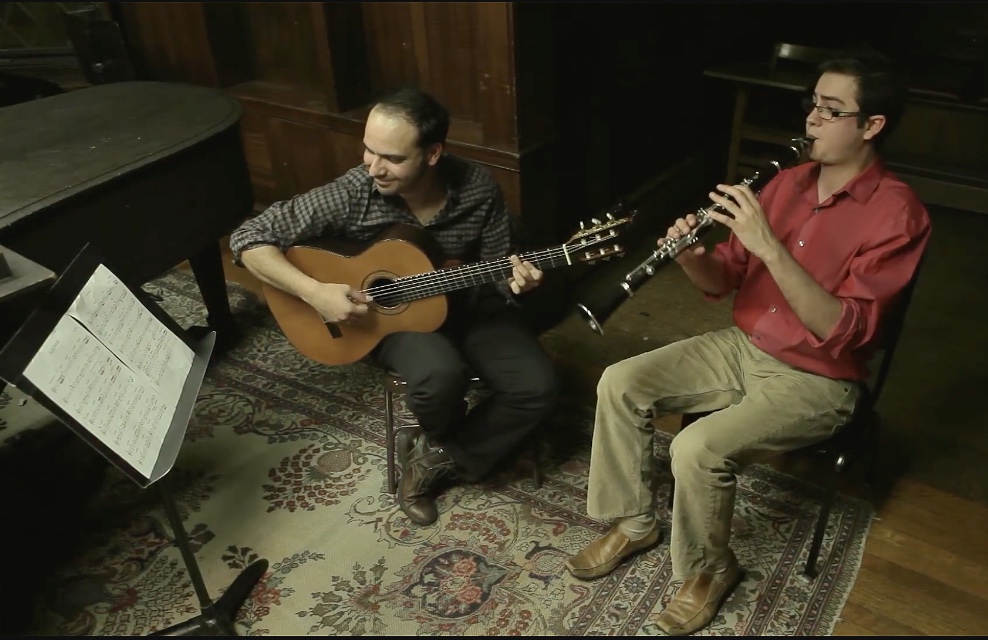 José playing classical guitar alongside a clarinetist